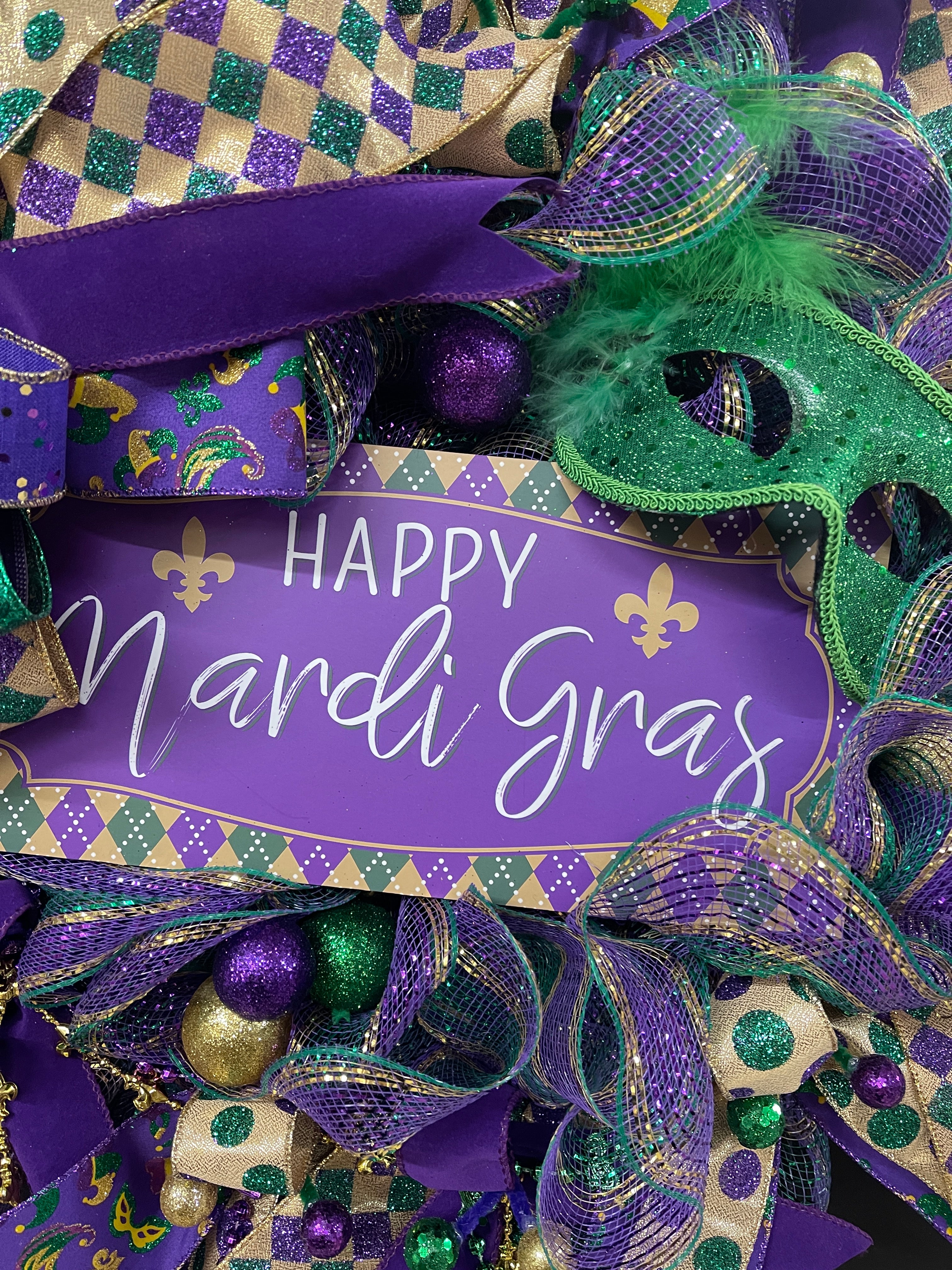 Close Up Detail of Happy Mardi Gras Sign with Fleur De Lies, and Purple, Green and Gold Harlequin Print