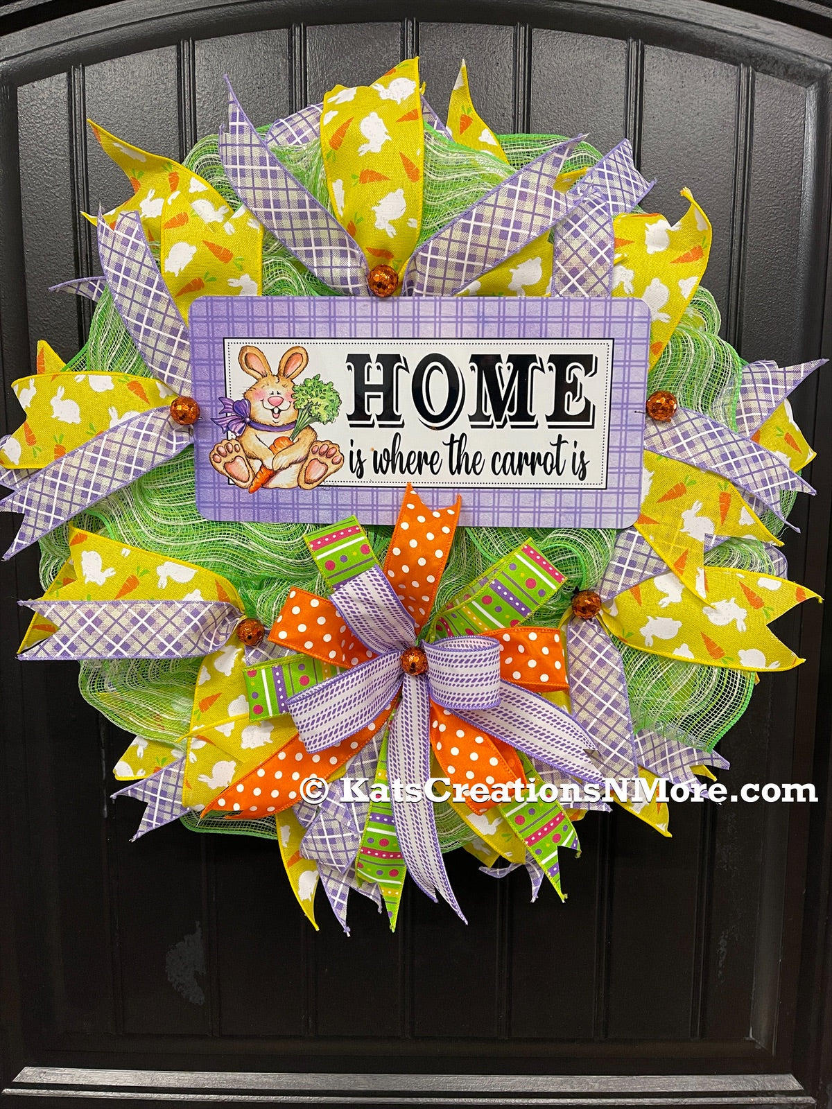 Home is Where the Carrot Is Easter Bunny Wreath with Yellow, Purple, Green, Orange and White Ribbons and Bow on a Black Door