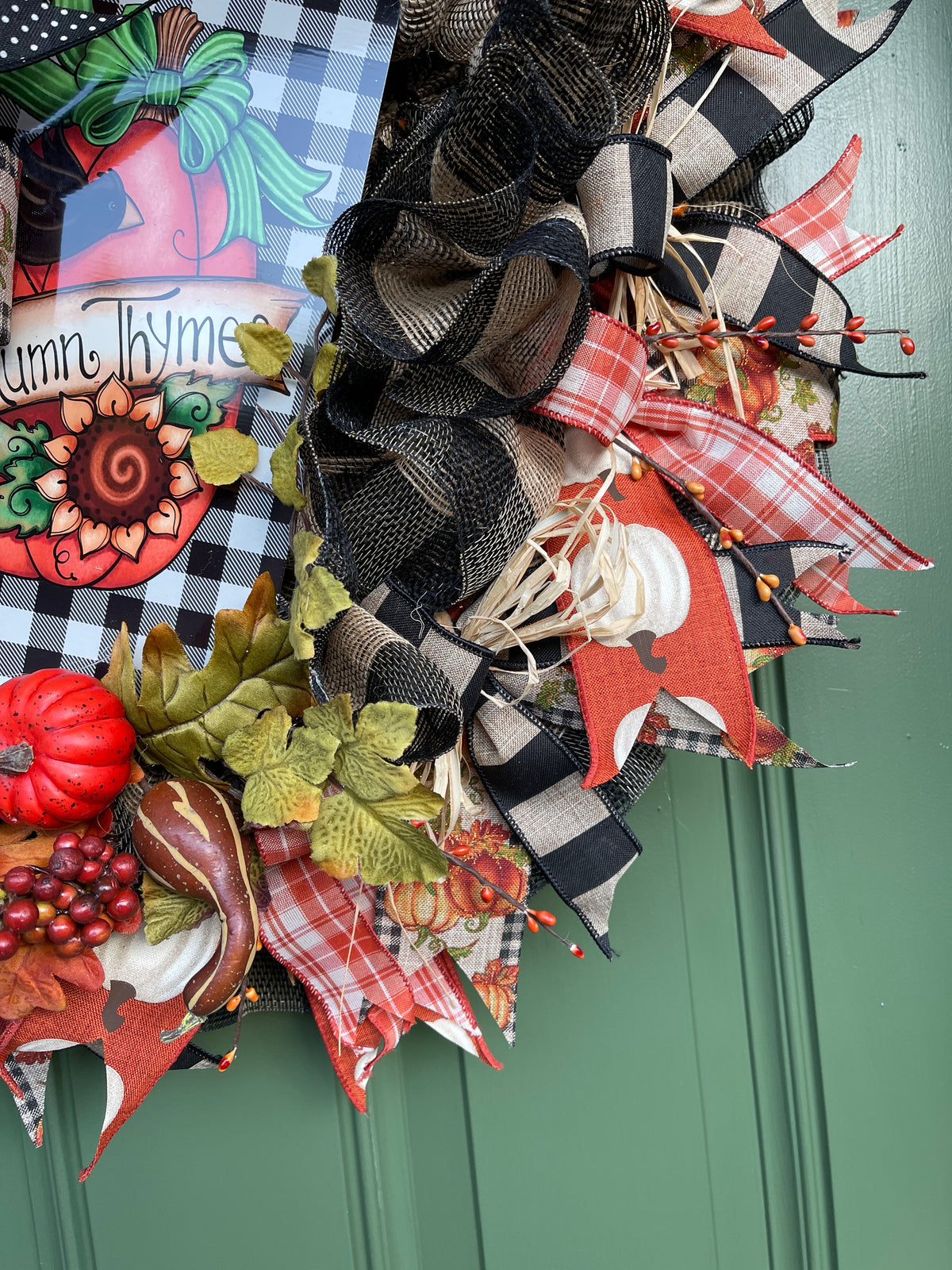 Close Up of Black and Tan Deco Mesh, Orange Pip Berries, Raffia, Oak Leaves and Artificial Pumpkins and Squash among Fall Colored Ribbons