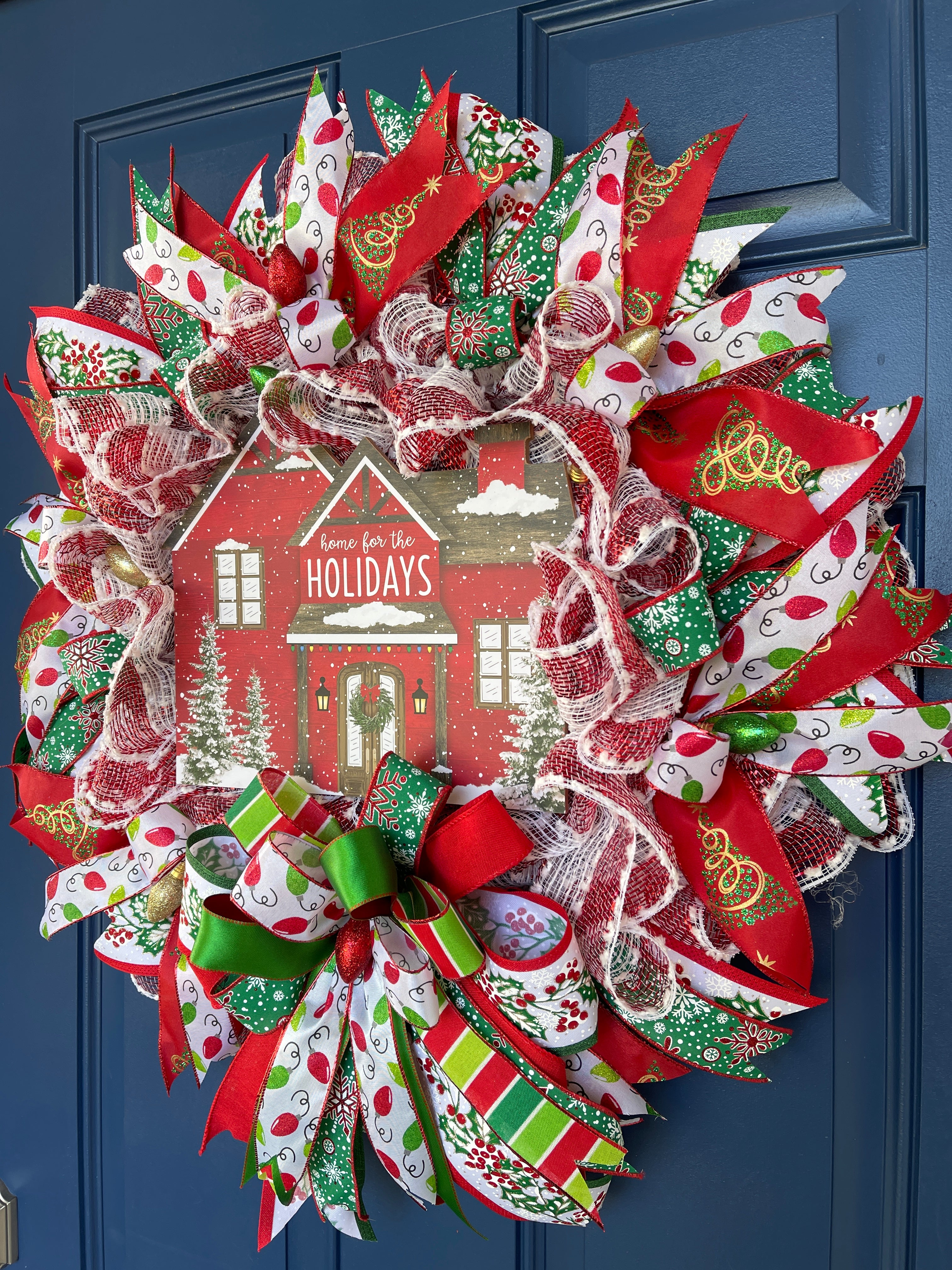 Right Side View of Red, White and Green Home for the Holidays Christmas Deco Mesh Wreath on a Blue Front Door