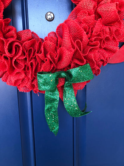 Close up of Green Glitter Ribbon bow with a Green Ball in the center on a Red Burlap Wreath 