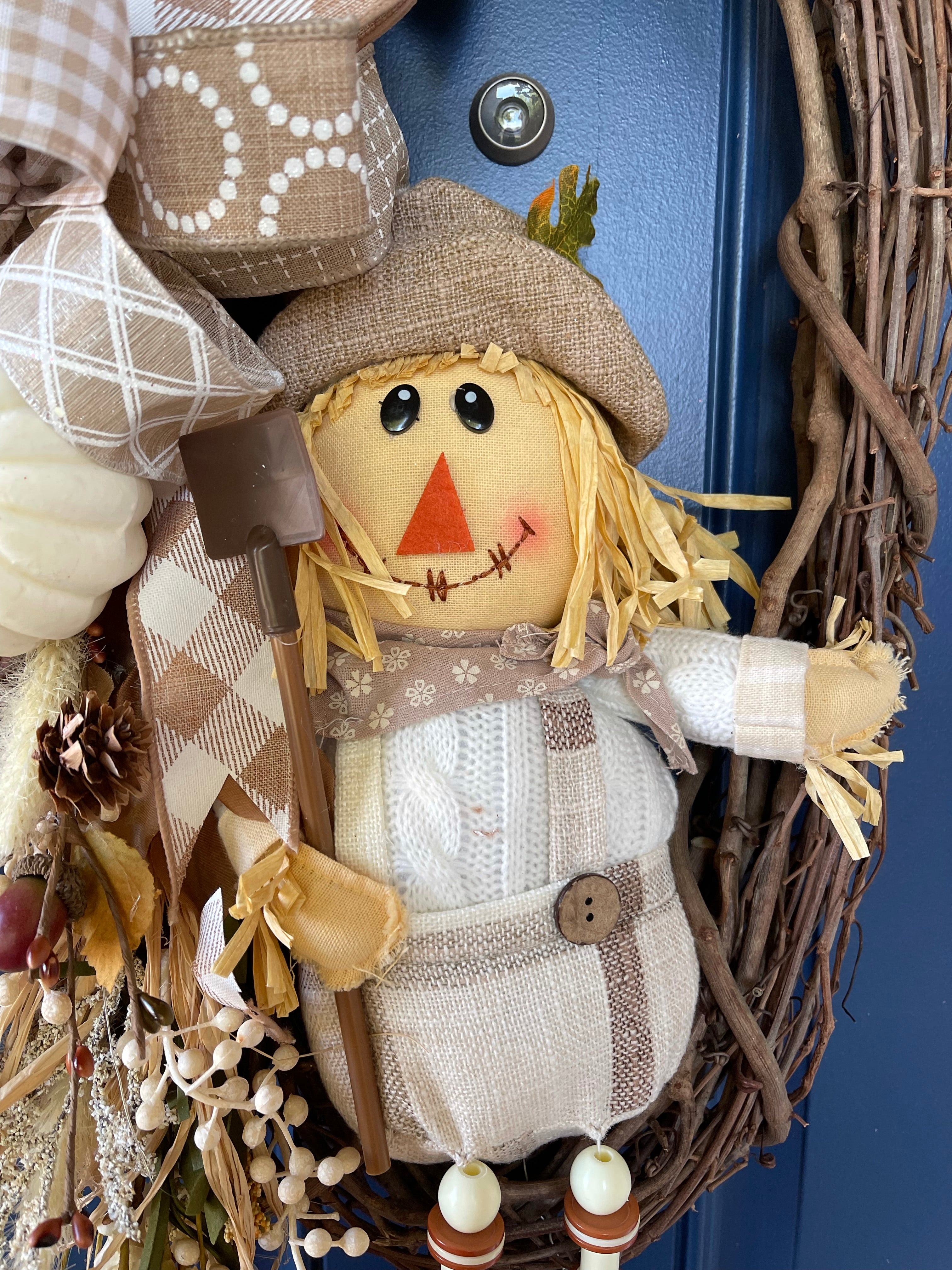 White and Tan Plush Scarecrow wearing overalls holding a shovel on a grapevine wreath