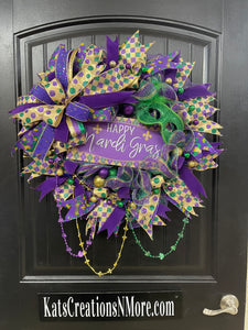 Purple, Green and Gold Mardi Gras Wreath with Beads, Balls, Mask and Bow on a Black Door