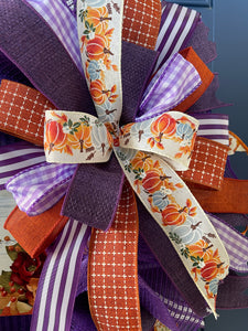 Close Up of Bow Featuring Ribbons with Blue and Orange Pumpkins, Solid Orange and Purple, Orange with White Stitching, Purple and White Gingham and Striped Ribbon