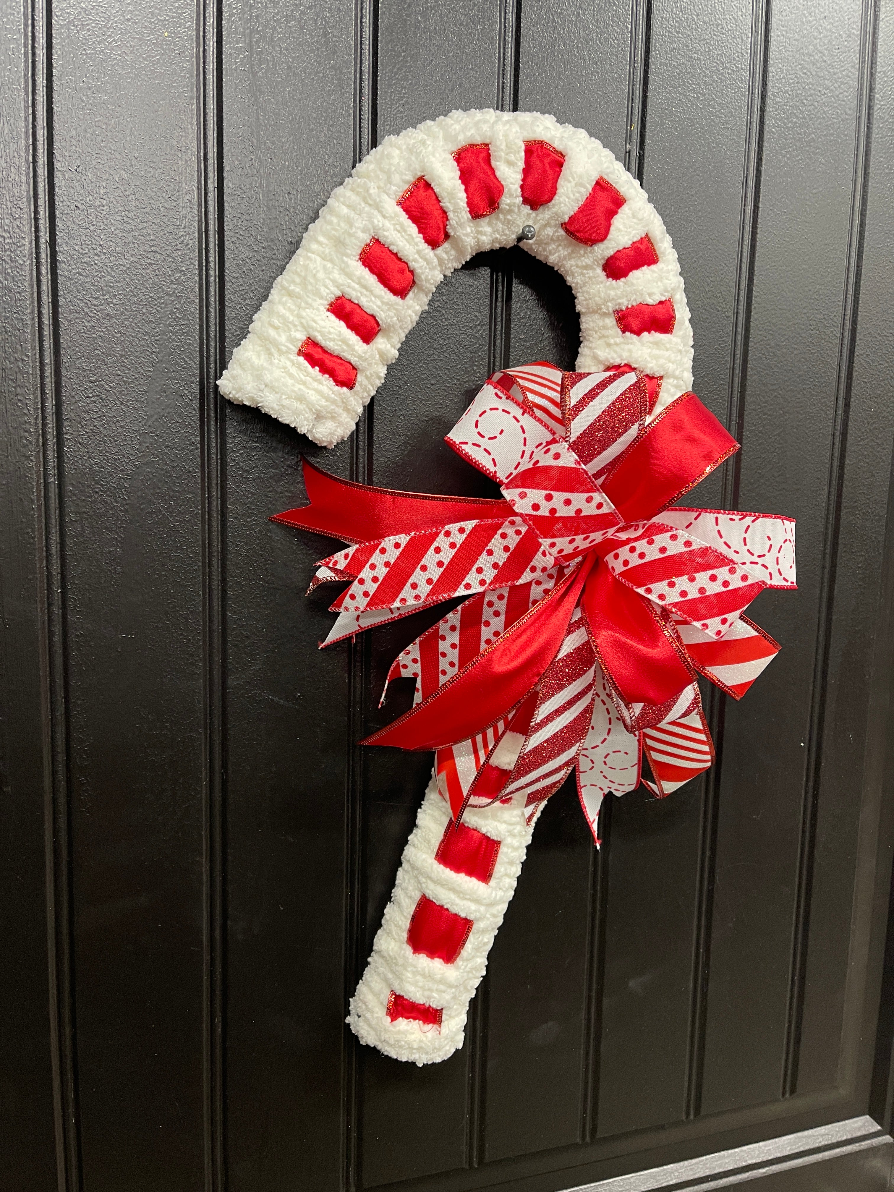 Left Side View of  Red and White Candy Cane Chenille Yarn and Ribbon Christmas Wreath with Red and White Striped Bow for Front Door. 