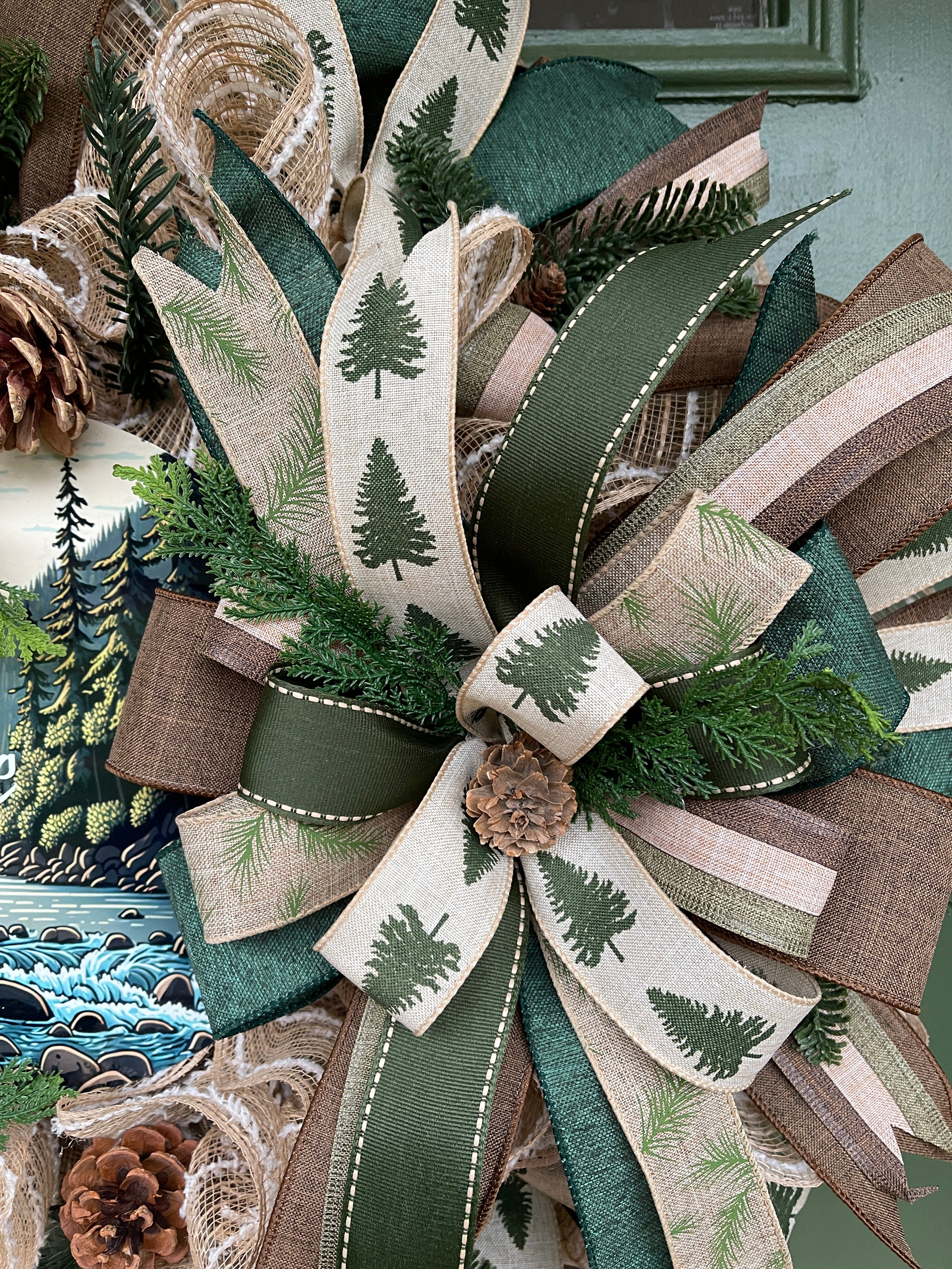 Close Up Detail of Bow with Pinecones, Pine Sprigs, and Ribbons with Pine Trees, and Pine Branches, along with Brown, Tan and Green