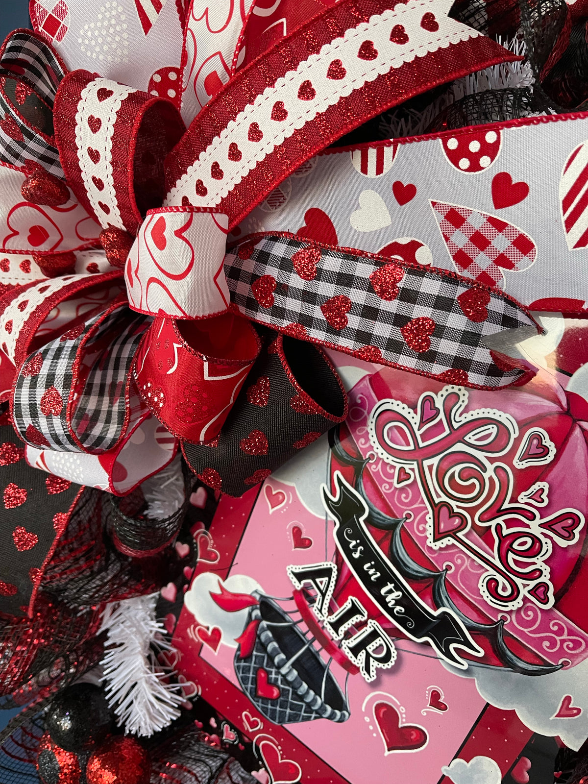Red, White and Black Heart Filled Wreath with a Love its in the Air Hot Air Balloon sign  with a Bow on a Blue Door