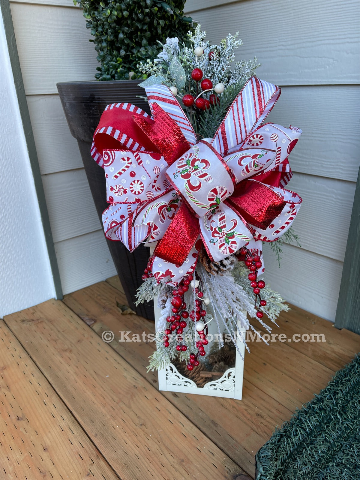 Red and White Candy Cane and Peppermint Lantern Swag with Evergreen Florals and Red Berries. 
