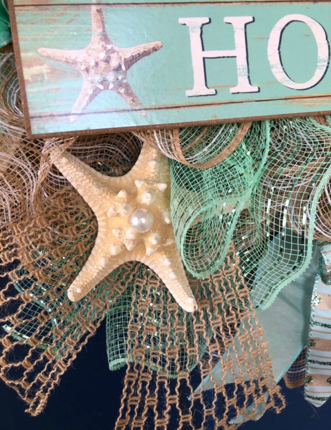 closeup showing the starfish and pearl on the beach house welcome wreath