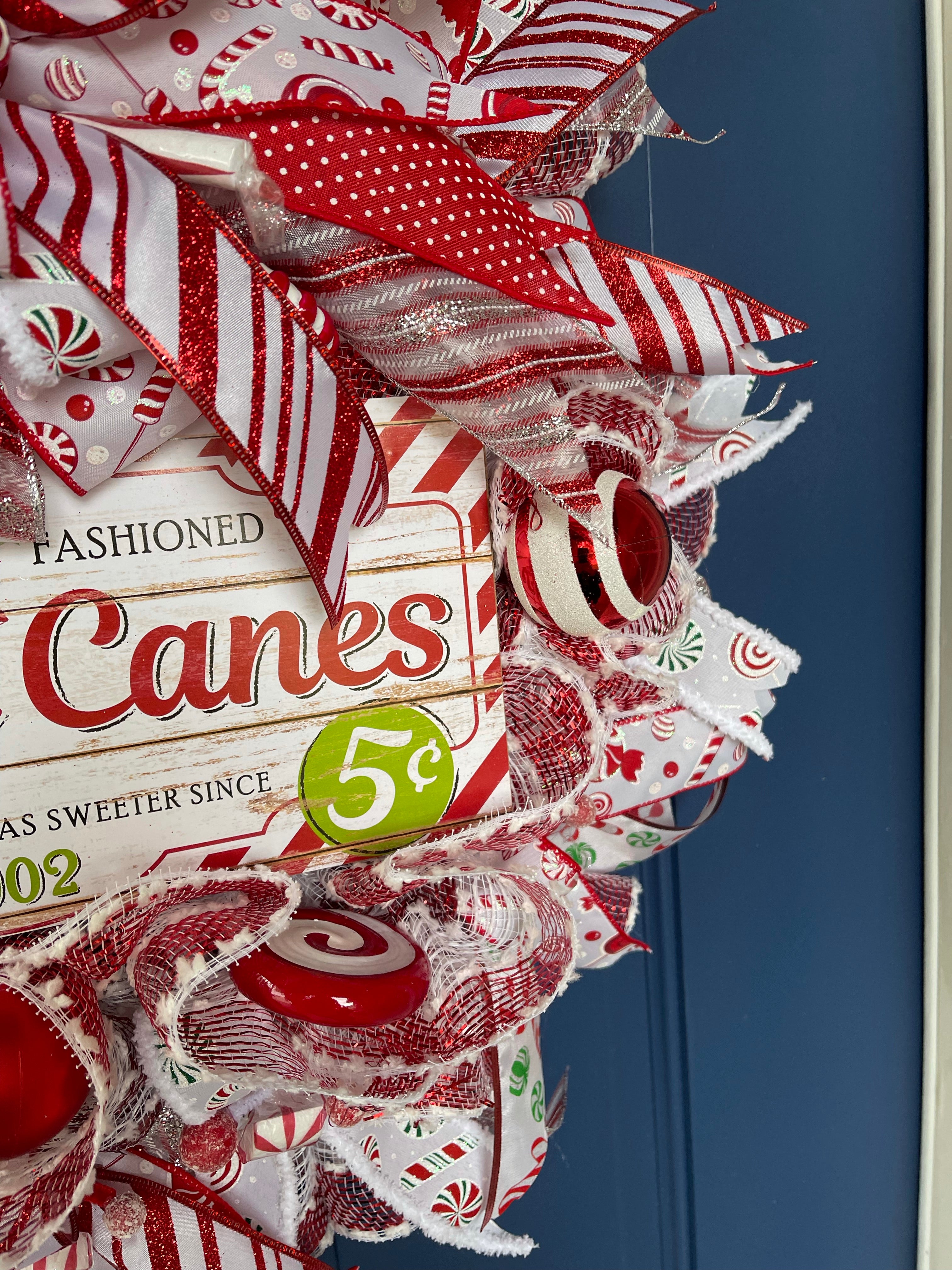 closeup of white and red Christmas balls on the candy cane Christmas wreath
