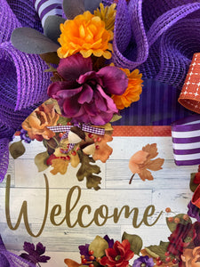 Close Up Details of Sign Featuring Fall Leaves and Flowers in Green, Brown and Purples with Orange Mums and Purple Delphiniums