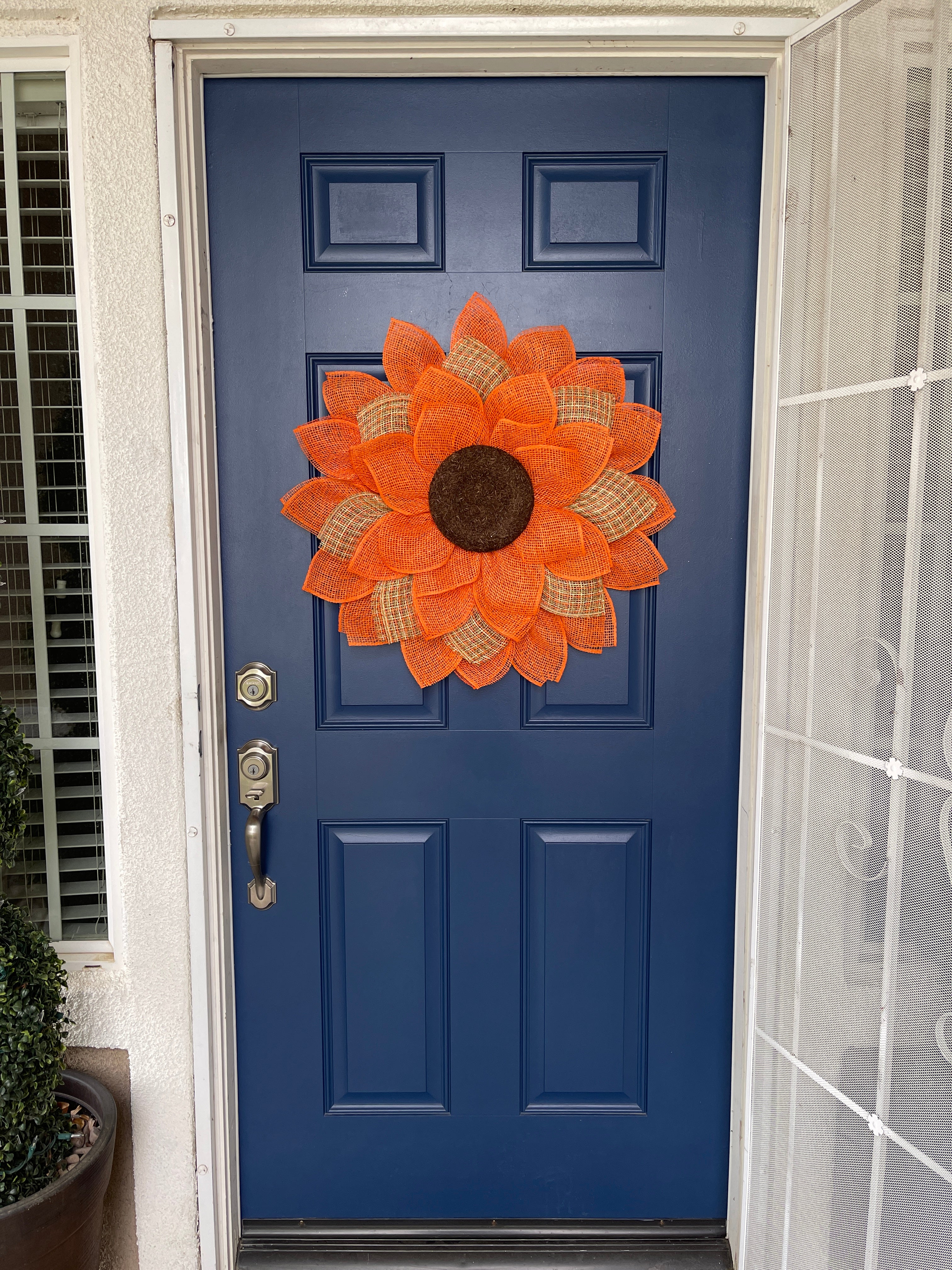 Poly Burlap Mesh Sunflower Wreath Featuring Orange and Patterned Colors of Yellow, Brown and Orange with a Brown Center on a Blue Door 