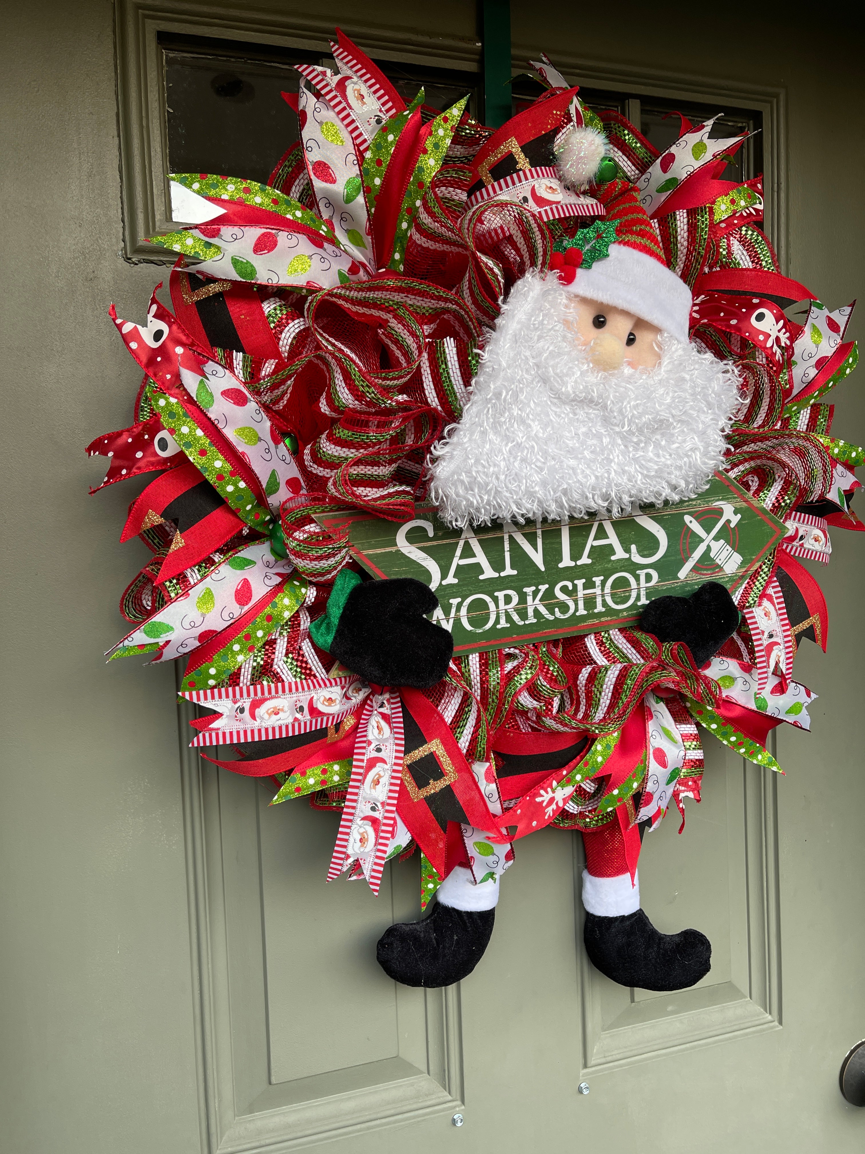 Left Side View of Santa Claus Plush Workshop Red, White and Green Workshop Wreath on a Green Front Door